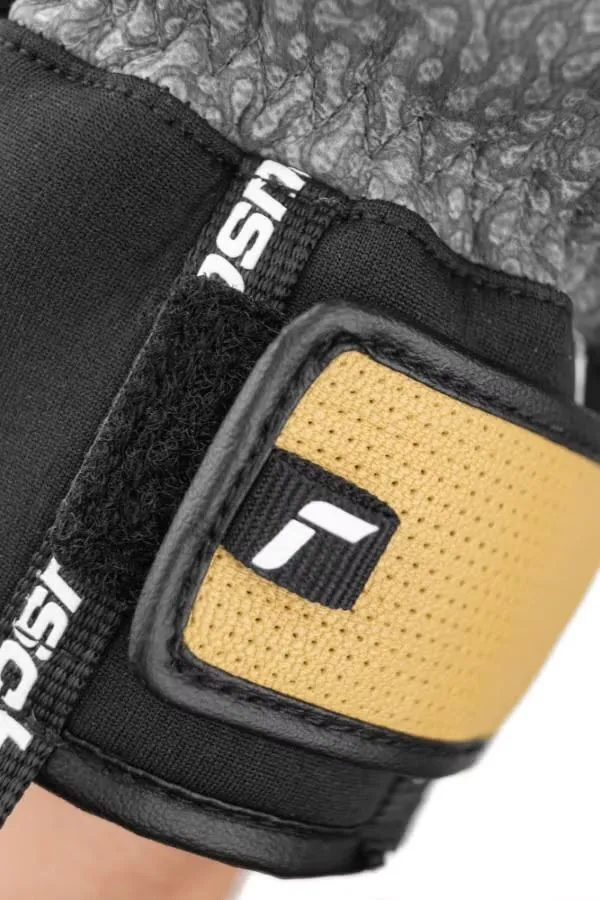 Primo piano del guanto Reusch Henrik Kristoffersen. Sono visibili la chiusura in velcro, il logo del marchio e l'inserto in pelle.