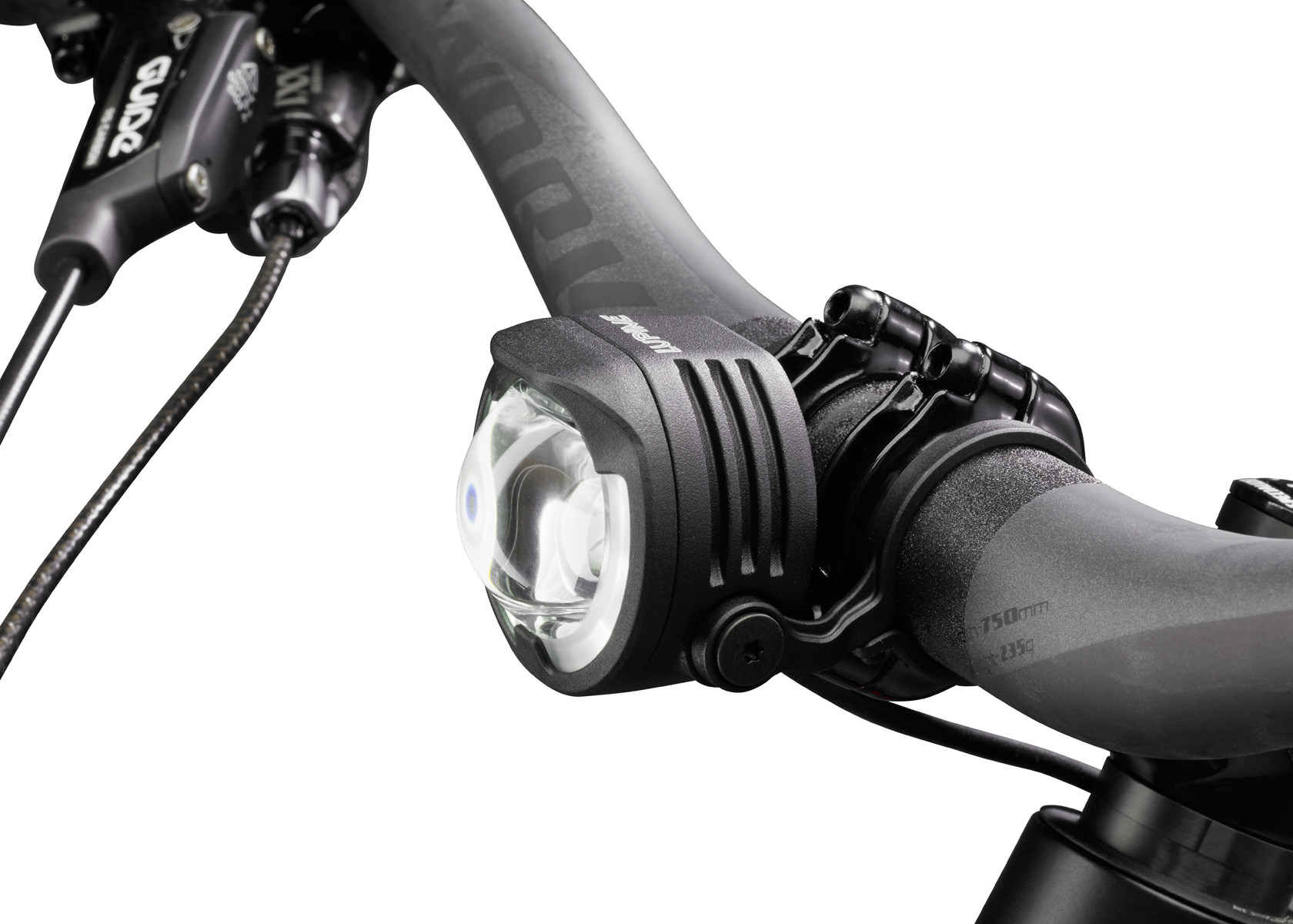 Nahaufnahme: Lupine E-Bike Beleuchtung am Fahrradlenker montiert. Die Lampe ist schwarz und hat ein klares Glas.