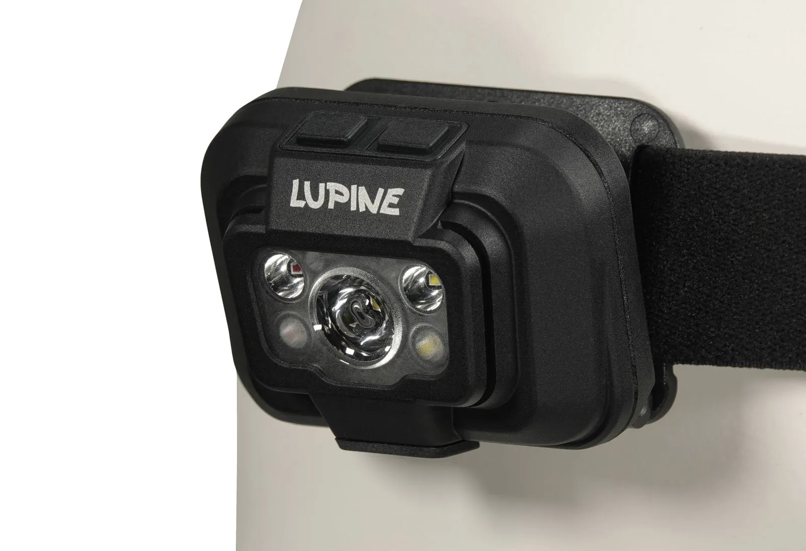 Vue détaillée de la lampe frontale Penta avec le logo Lupine, deux boutons et des lampes LED. Le bandeau noir est fixé.