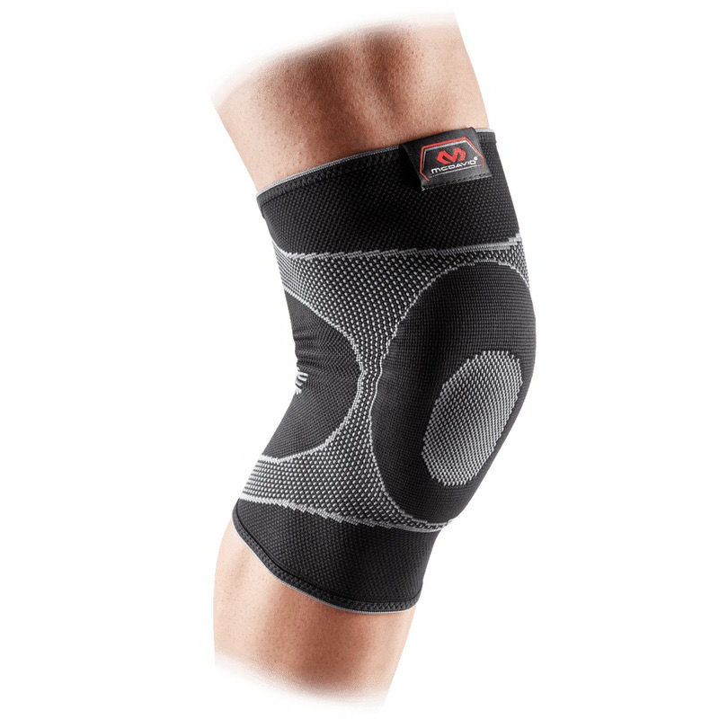 Nahaufnahme: Bein mit schwarzer, elastischer Kniebandage und eingearbeiteten grauen Gel-Streben, McDavid Logo sichtbar.