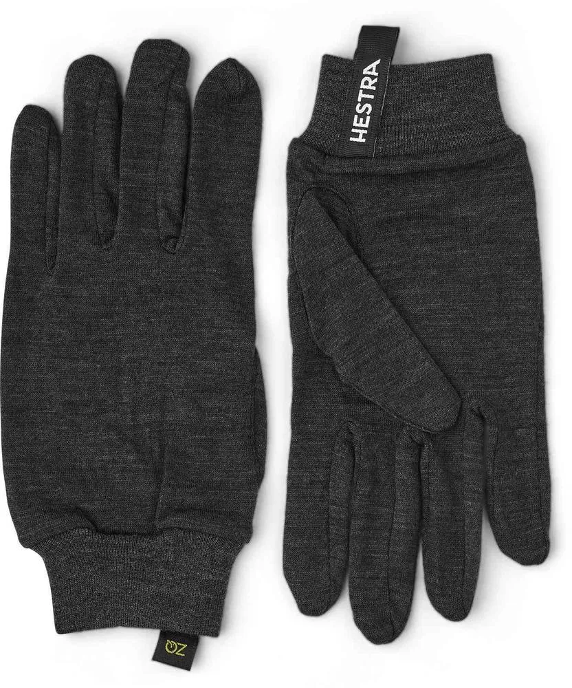 Graue Merino Wool Liner Active Innenhandschuhe von Hestra, flach liegend mit Markenkennzeichnung.