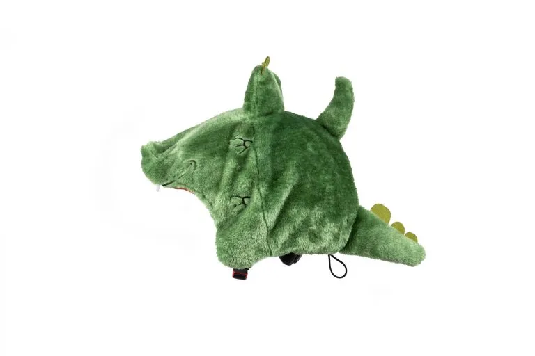Copricasco da sci in peluche verde a forma di coccodrillo con corna, denti e coda su sfondo bianco.