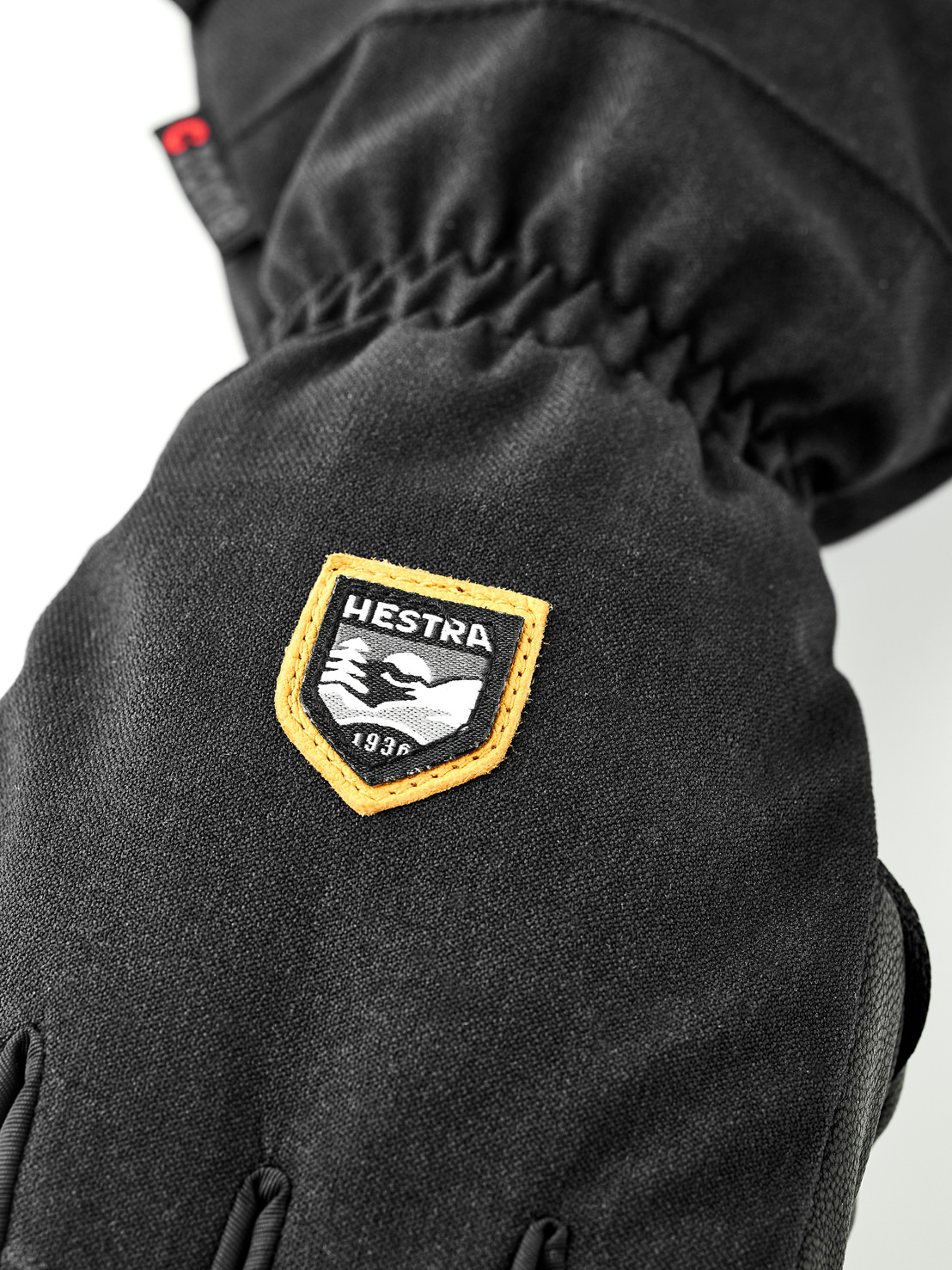 Hestra Gant noir Vue détaillée d'un gant noir avec le logo Hestra représentant des montagnes et l'année de fondation 1936.