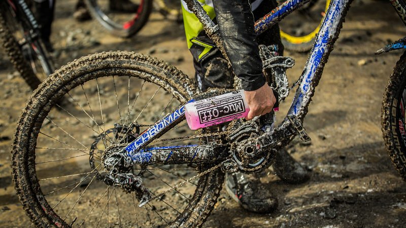 Le vélo souillé par la boue est traité avec le nettoyant pour vélos rose Muc-Off, photo de détail.