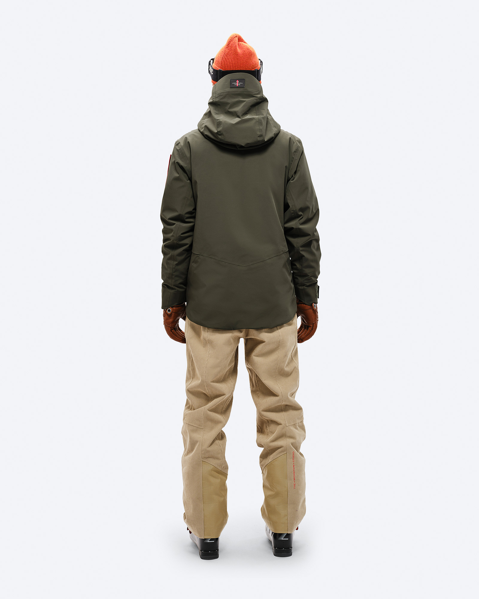 Veste de ski en vert forêt Vue de dos d'une personne en Forest Green S-3 Carv Insulated Stretch Jacket avec lunettes de ski, bonnet, gants, pantalon et chaussures de ski.