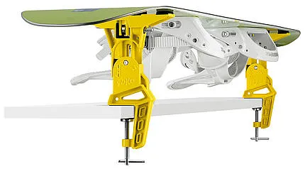 Gelber Toko Universal Adapter hält Snowboard auf Ski Vise Worldcup, montiert auf einer Werkbank.