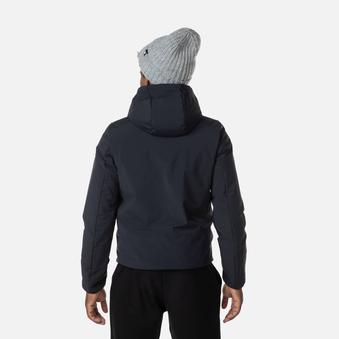 Schwarze Kapuzenjacke Rückansicht Rückansicht einer schwarzen Rossignol Stretch Quilted Kapuzenjacke, getragen von einer Person mit grauer Mütze.