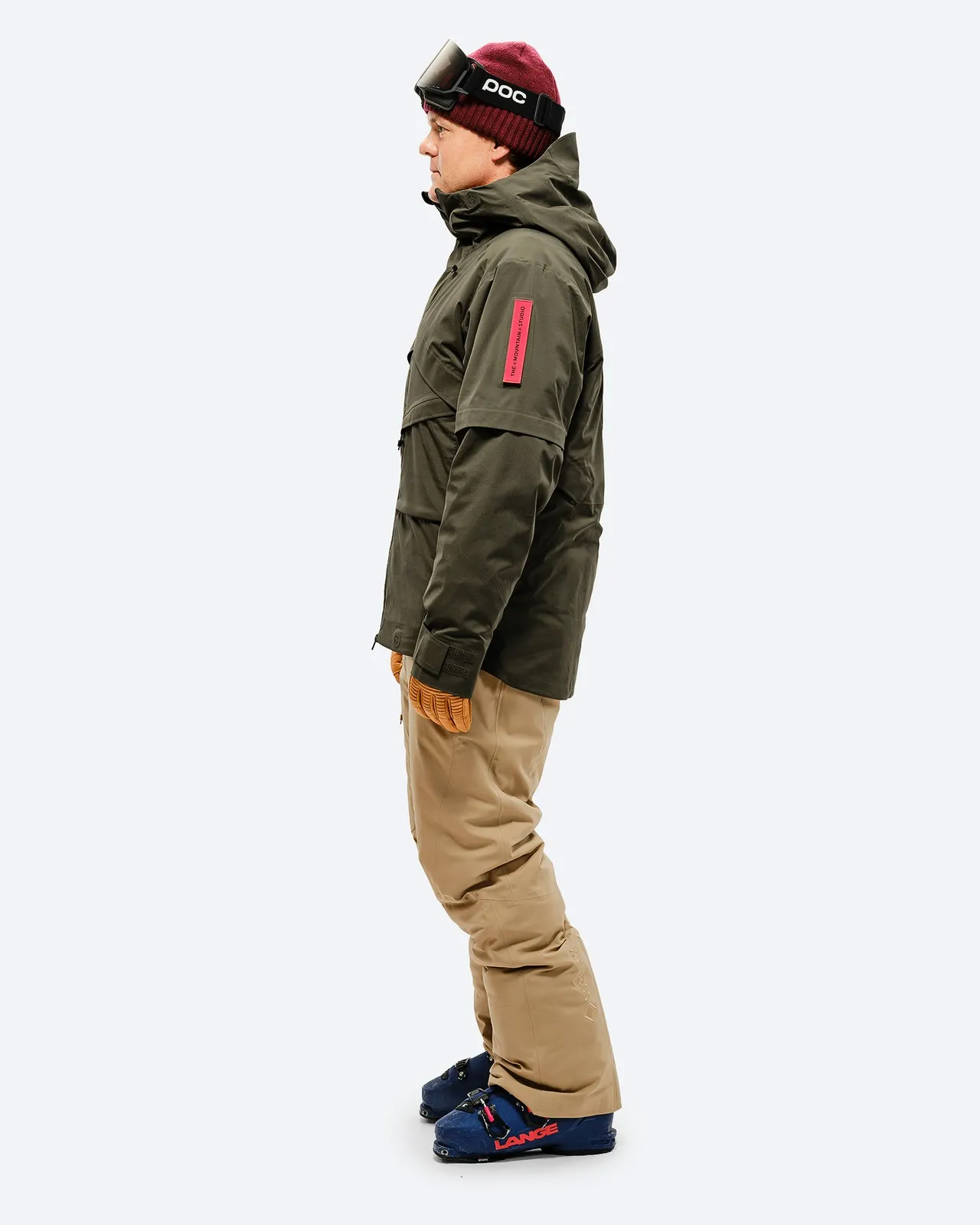 Person from the side in ski outfit with sand-colored GORE-TEX 2L Stretch Insulated Pant and ski boots.
