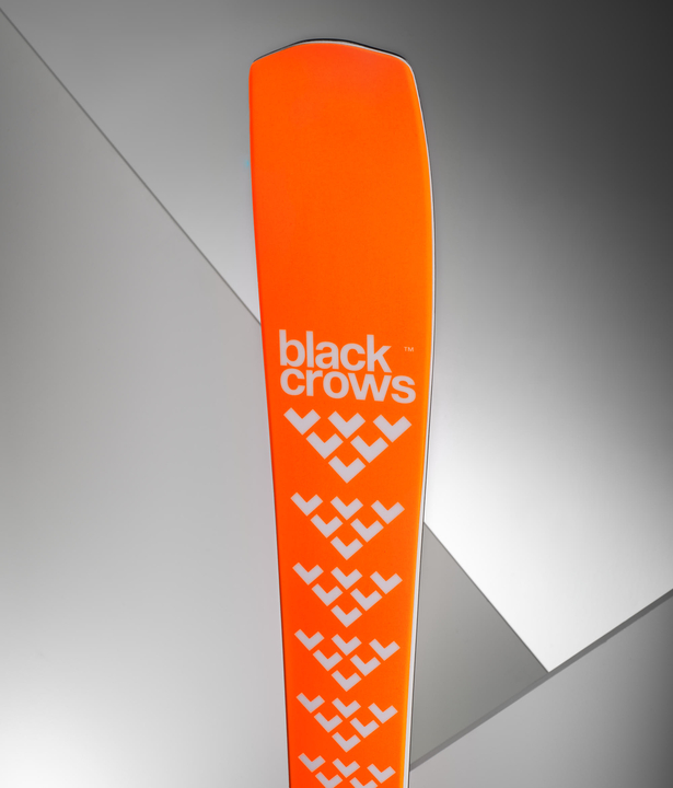 Vue détaillée du ski Black Crows Mirus Cor, avec une surface orange et un logo blanc.