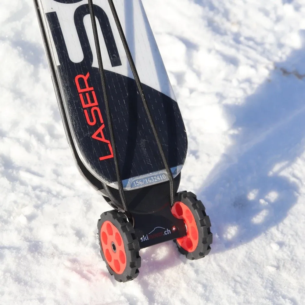 Ski with mounted, red Skimover Easy on snow. The Skimover has two wheels. The ski end is black and white.