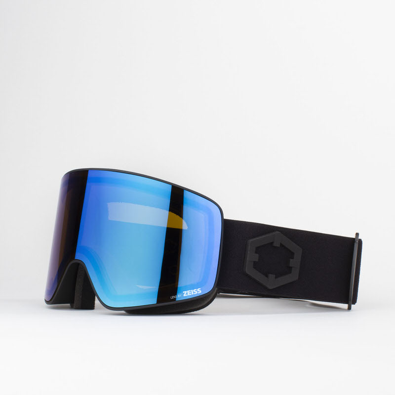 Schwarze Skibrille "Out Of Void" mit blauer, zylindrischer Zeiss-Linse und breitem, schwarzen Kopfband auf hellem Grund.