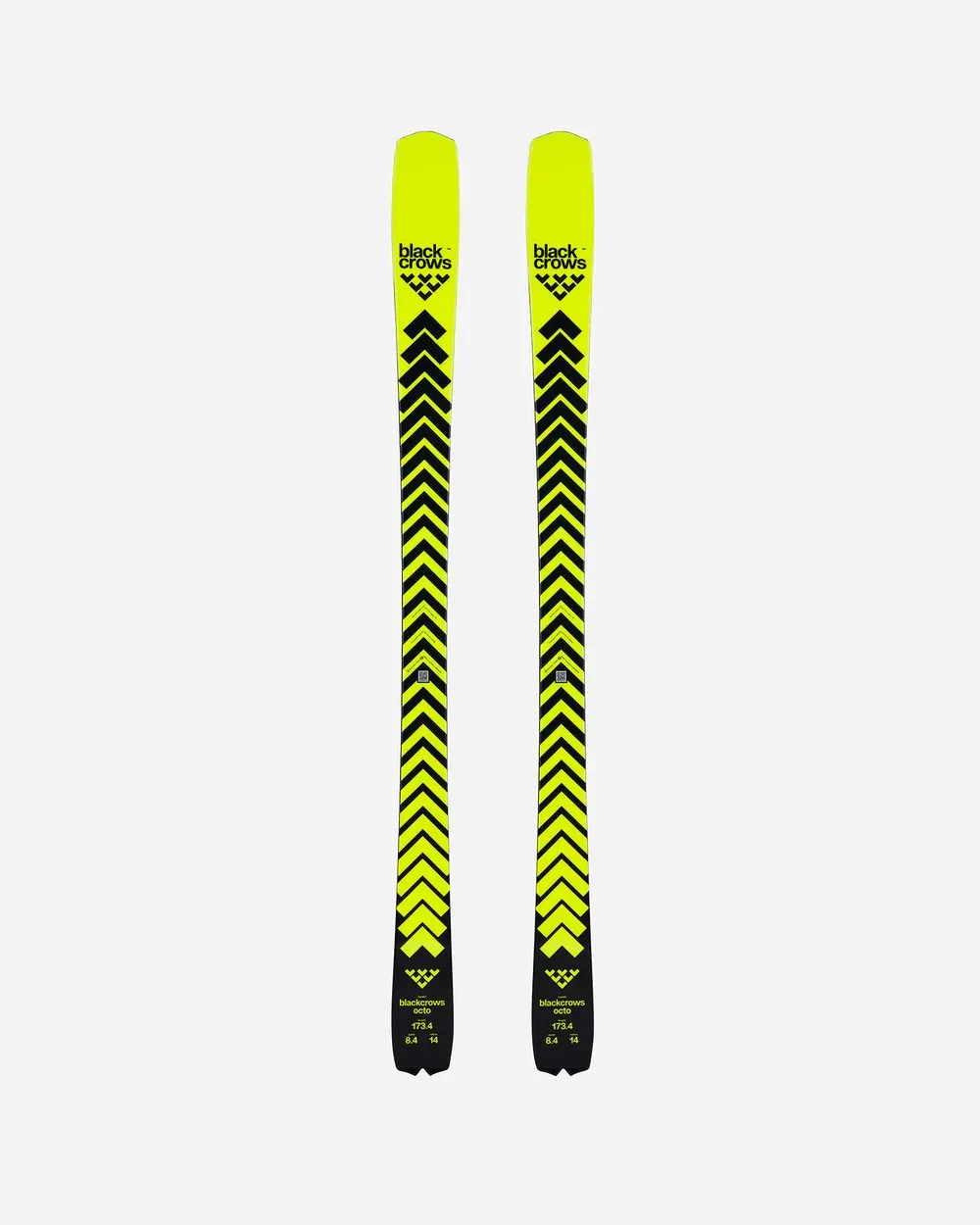 Zwei Skier, gelb mit schwarzen Chevron-Pfeilen, stehen vertikal nebeneinander vor einem weißen Hintergrund.
