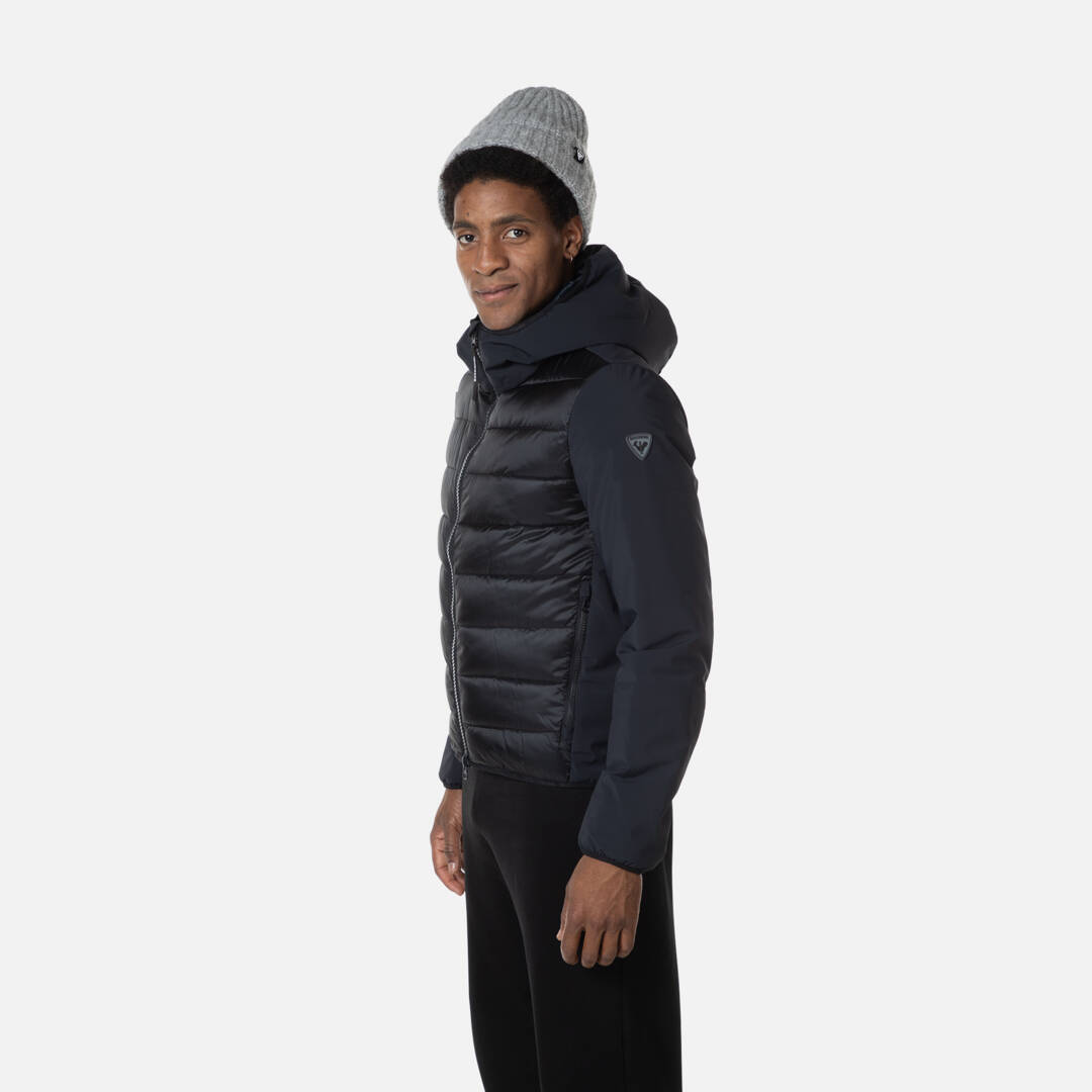 Mann im Rossignol Hoodie Mann mit Mütze trägt Rossignol Stretch Quilt Hoodie JKT in Schwarz, Seitenansicht.