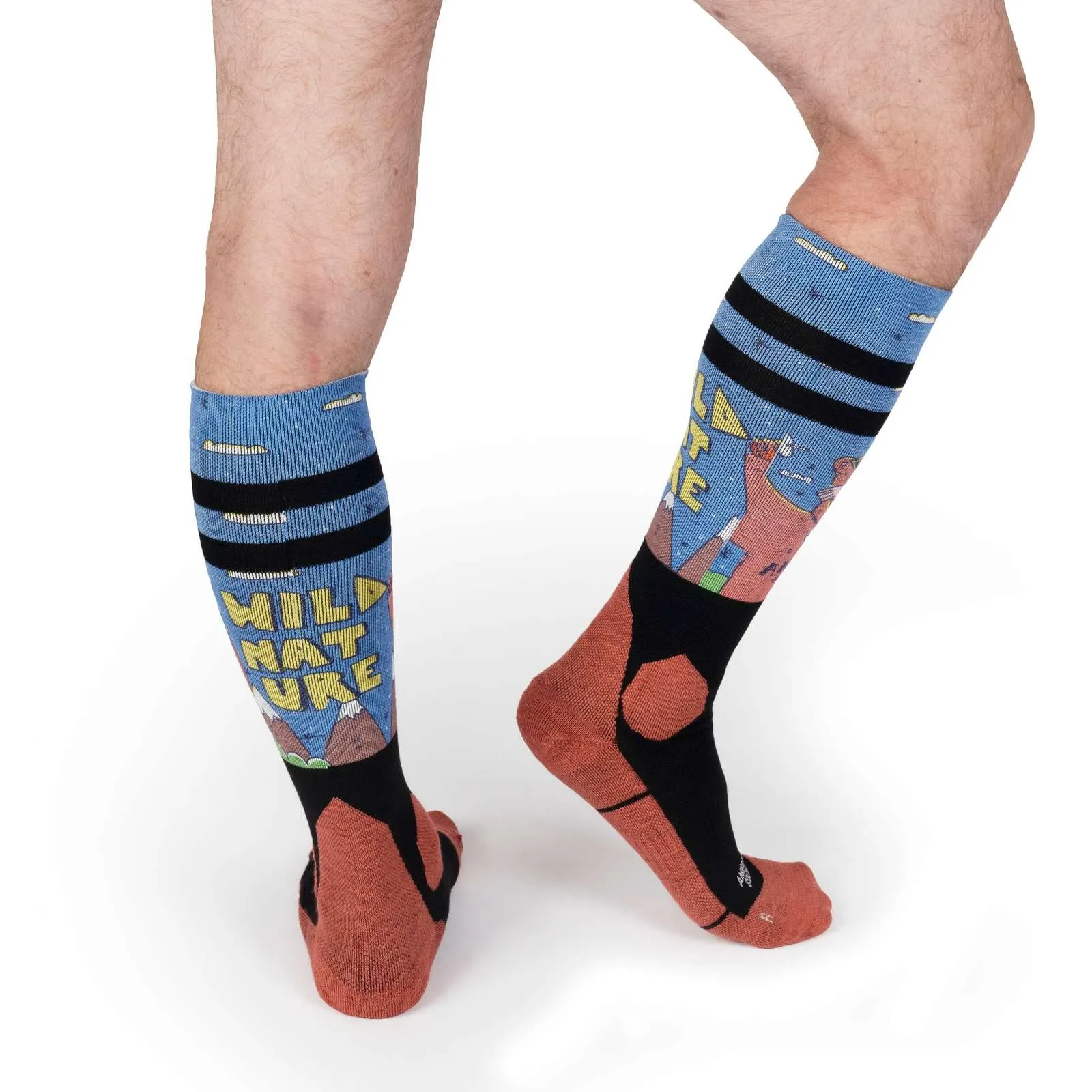 Gambe con calze da neve alte fino al ginocchio, di colore azzurro con scritta "Wild Nature", montagne, disegni e strisce nere.