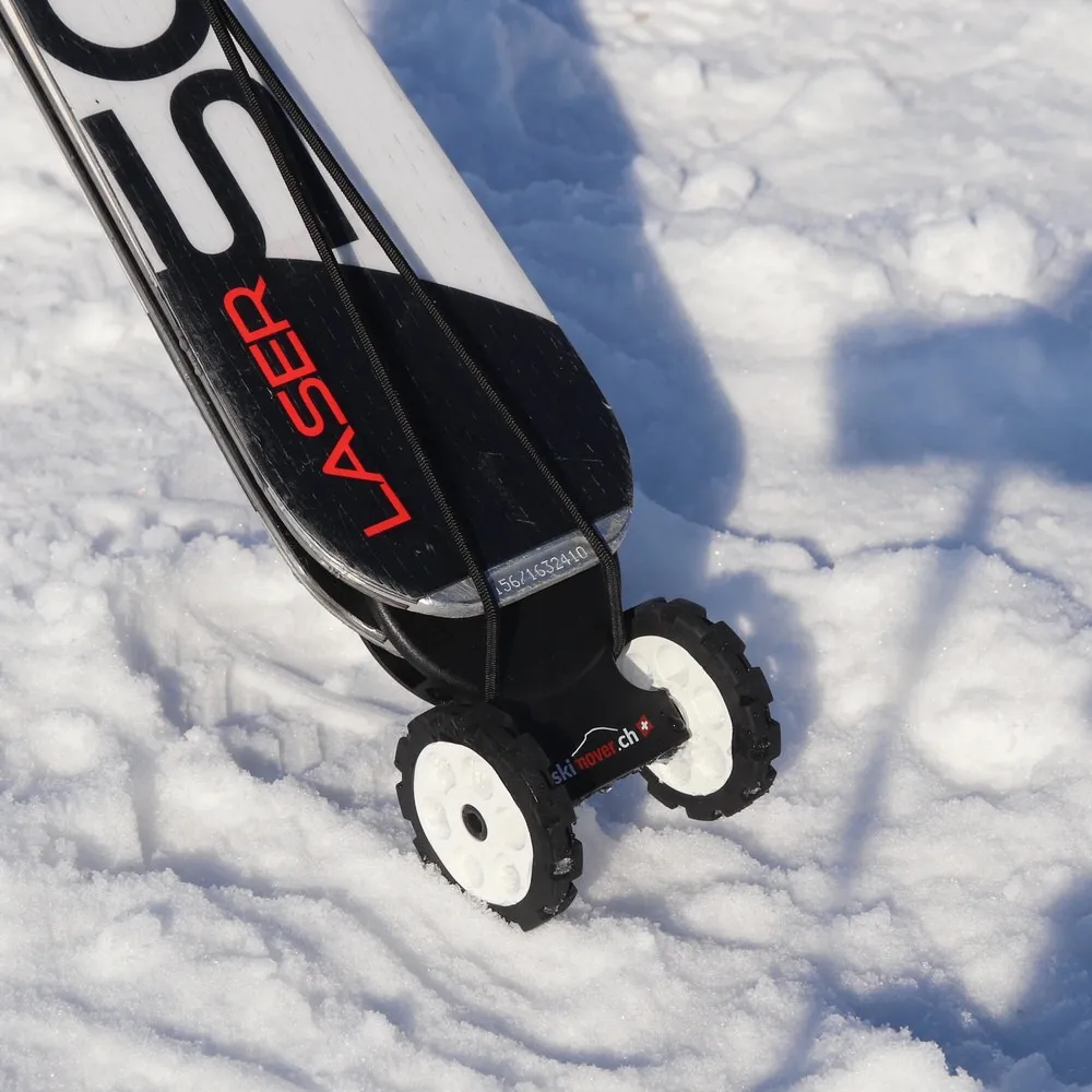 Skis with mounted Skimover Easy wheels in the snow, close-up.