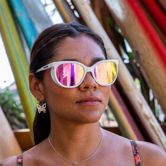 Weiße Sonnenbrille Miami Nahaufnahme einer Person, die eine weiße Sonnenbrille "The Fondue Miami Nights" mit farbigen Gläsern trägt.