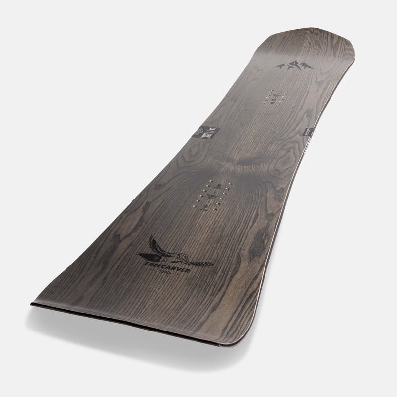 Ein Jones Freecarver 6000s Snowboard mit Holzmaserung und dem Aufdruck "Freecarver 6000s" im unteren Bereich.