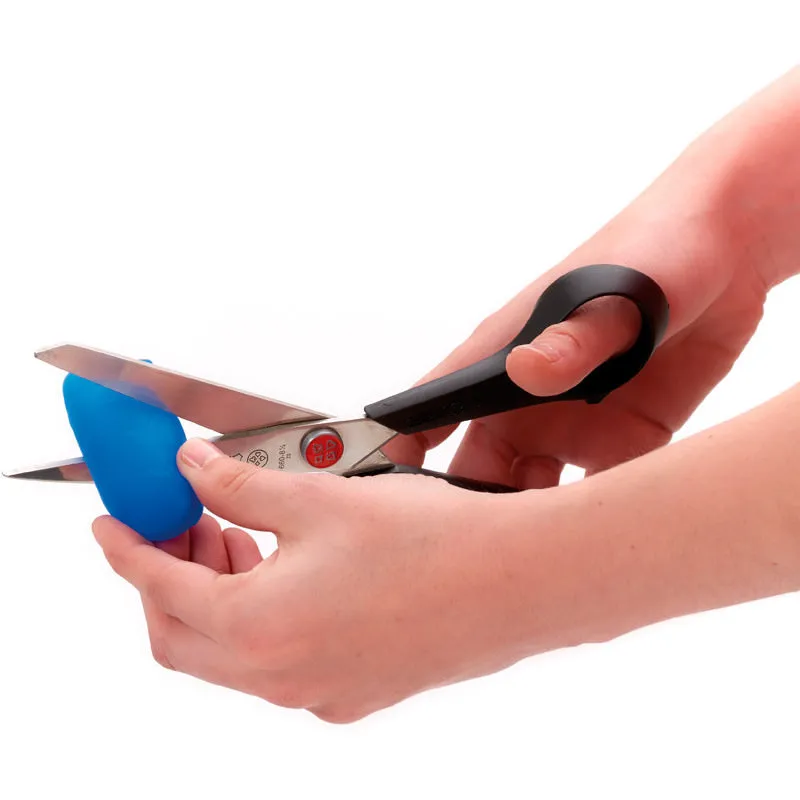 Une main découpe avec des ciseaux un embout bleu Sidas Gel Toe Cap.