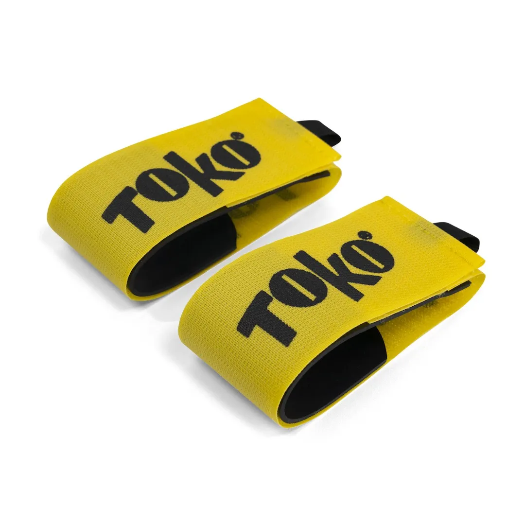 Two yellow Toko ski clips with black lettering and black lining on a white background.