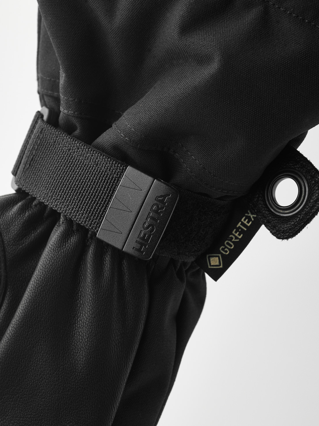 Hestra Moufles Army Leather Vue détaillée d'une moufle noire Hestra Army Leather Gore-Tex avec lanière et étiquette Gore-Tex.
