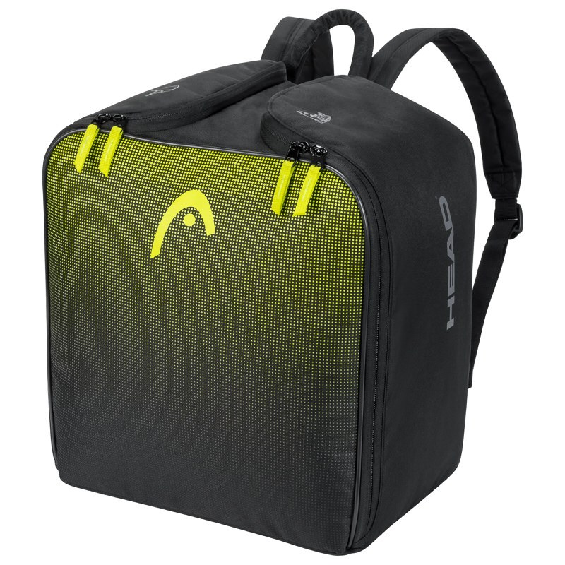 Sac à dos pour chaussures de ski Head noir avec un logo jaune et des fermetures éclair. Les bretelles sont également noires.