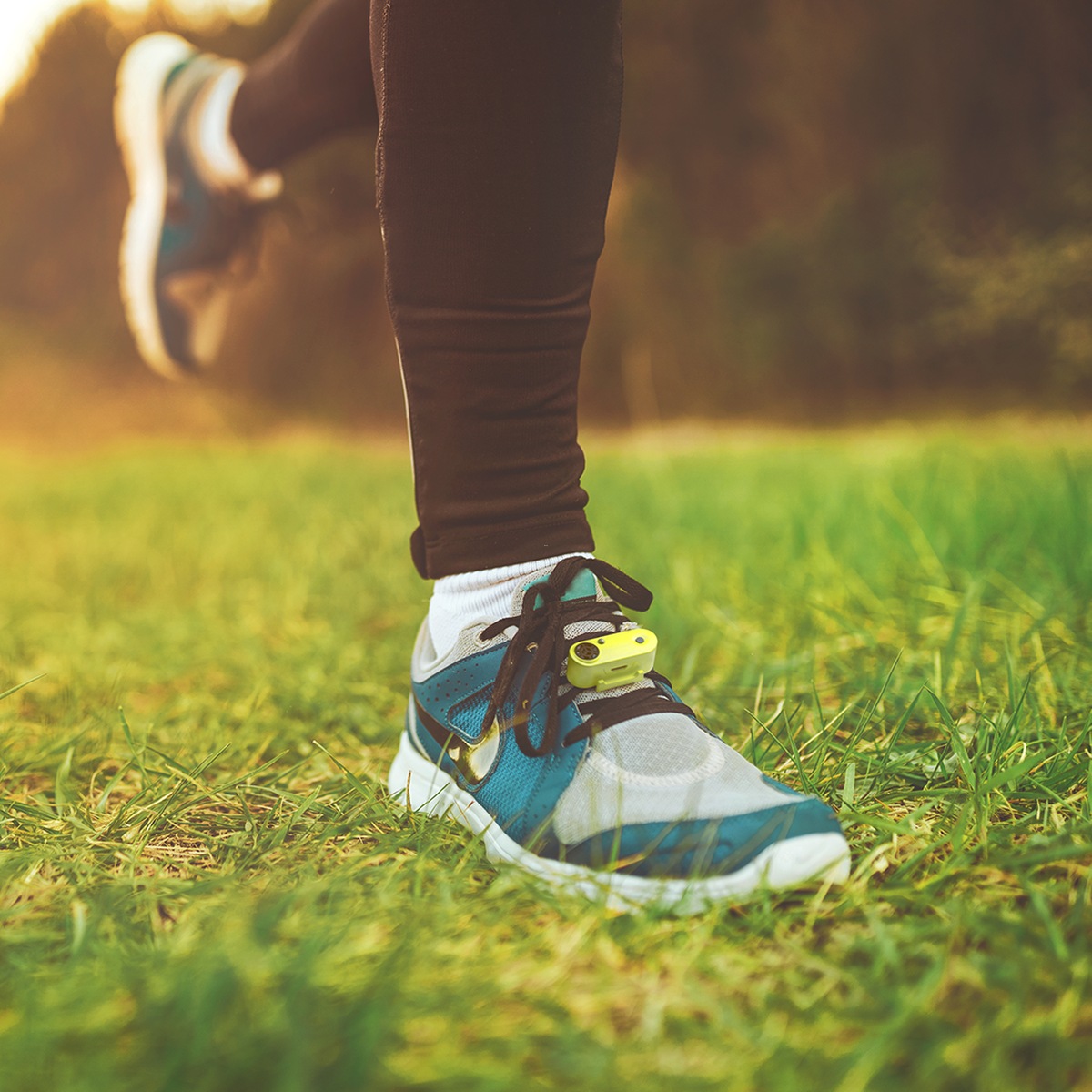 Coureur avec Tickless Run sur la chaussure, dans l'herbe. Dispositif de protection contre les tiques pour la chaussure de course.