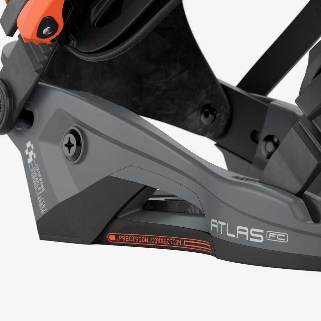 Nahaufnahme einer Snowboardbindung mit grauer Basisplatte und orangenem Detail. Aufschrift "ATLAS FC" und "PRECISION CONNECTION".