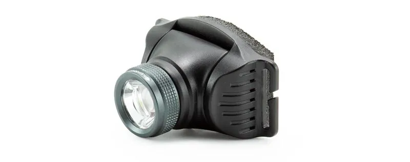 Primo piano della lampada frontale Suprabeam V3 Pro R, alloggiamento grigio scuro, anello argentato zigrinato intorno alla lente LED.