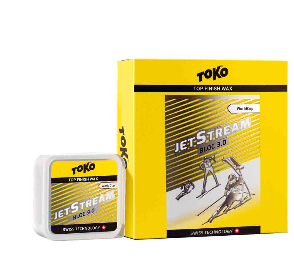 Gelbes Toko JetStream Bloc 3.0 Wax für Ski, Dose und Verpackung mit Skifahrer-Abbildung.