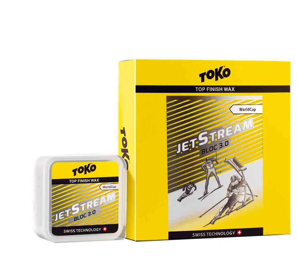 Gelbes Toko JetStream Bloc 3.0 Wax für Ski, Dose und Verpackung mit Skifahrer-Abbildung.