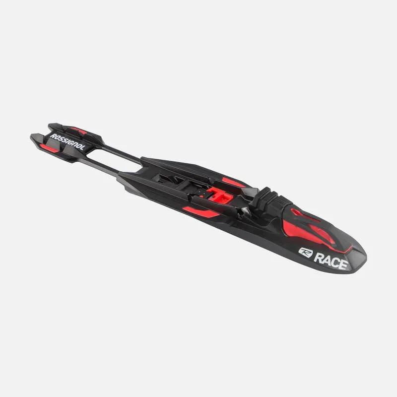 Fixation de ski Rossignol Nordic Race noire avec des accents rouges. La fixation est orientée en diagonale, du haut à gauche vers le bas à droite.