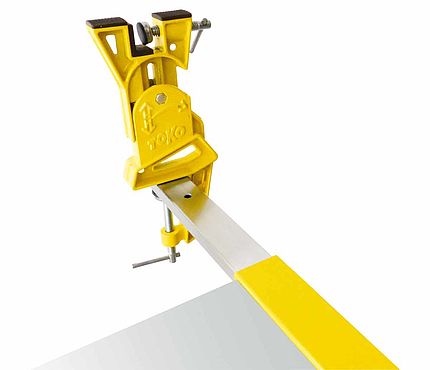 Tige d'extension jaune Toko Tige d'extension jaune Toko Extract Pole fixée à l'aide d'un serre-joint sur le bord d'une table.