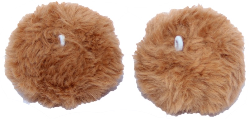 Deux pompons ronds et duveteux dans un ton brun chaleureux. Chaque pompon moelleux possède une petite boucle blanche pour l'attacher facilement aux accessoires d'hiver pour enfants, comme bonnets ou cagoules.