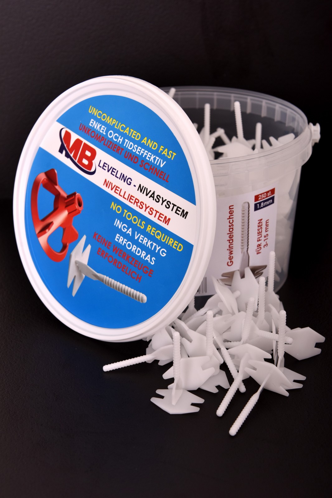 Seau avec languettes filetées Seau avec MB Leveling Languettes filetées 1.8mm. Des languettes blanches sont posées à côté sur un fond noir.