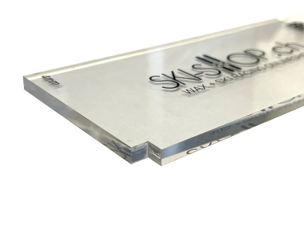 Close-up of a transparent 4mm plexiglass blade for ski wax, with logo imprint.