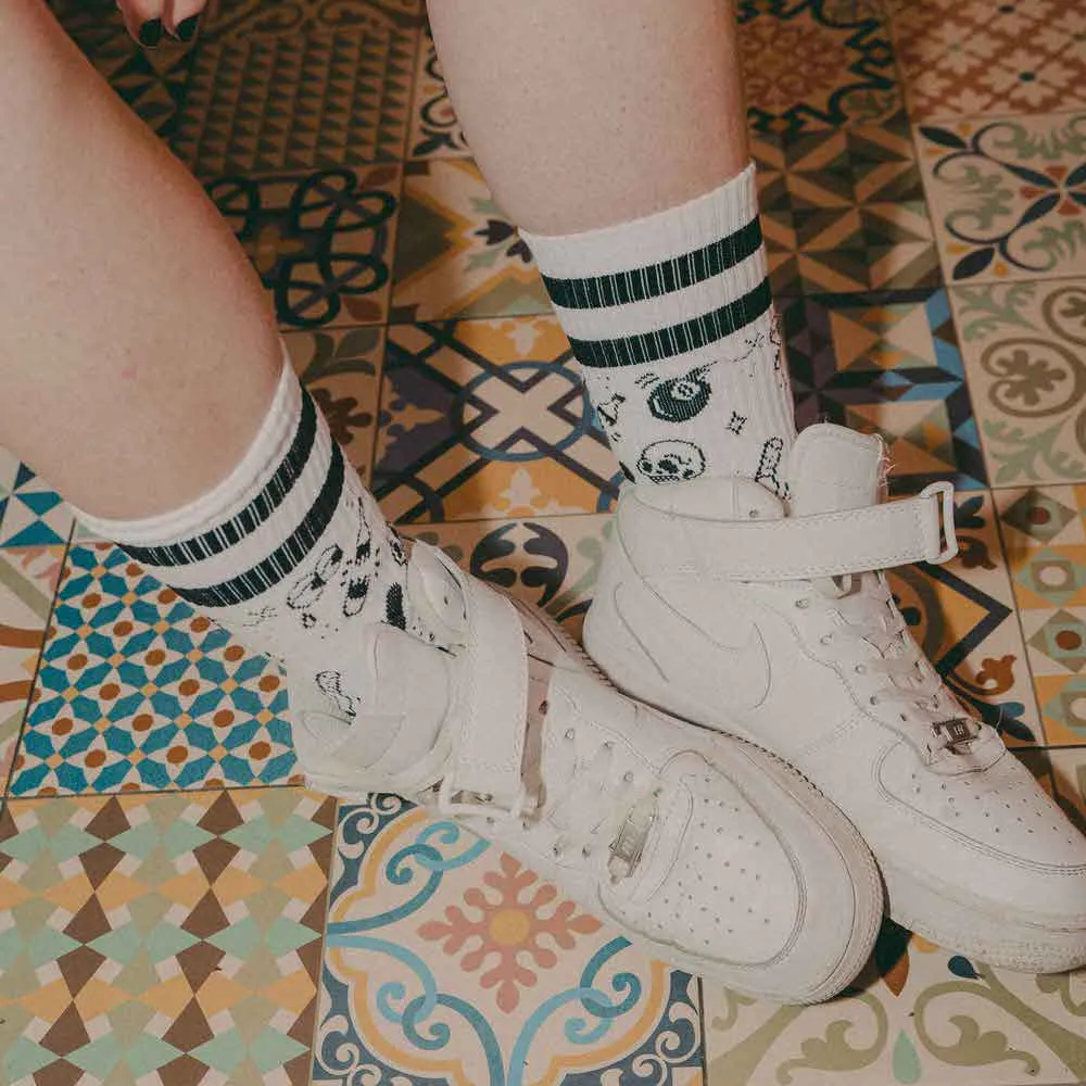 Legs with "Flash Tattoo - Mid High" socks and white shoes on a patterned tiled floor.