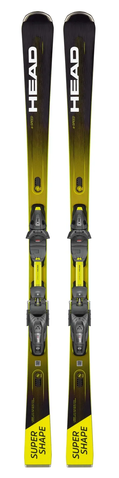 Deux skis, Head Supershape e-Speed, avec fixations, debout. Le jaune, le noir et le gris dominent le design.