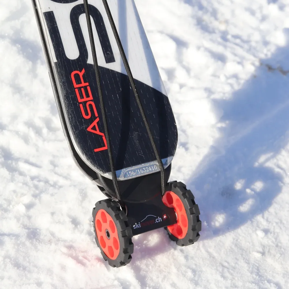 Ski with mounted, red Skimover Easy on snow. The Skimover has two wheels. The ski end is black and white.