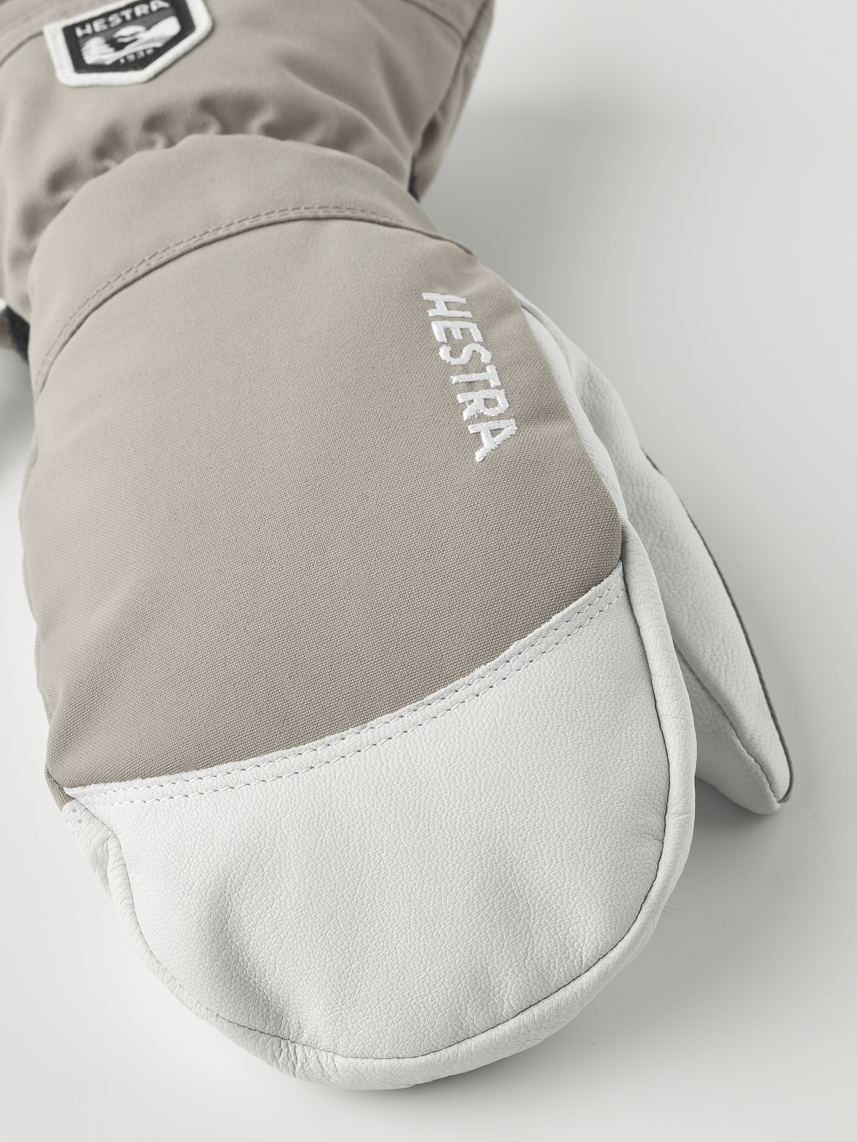 Hestra Gants en cuir Army Gros plan sur une moufle marron clair Hestra Army Leather Heli Ski Mitt avec du cuir blanc à l'extrémité.