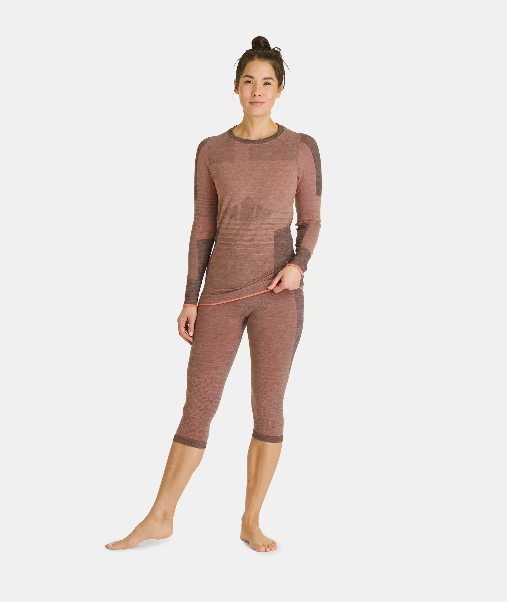 Femme avec 230 COMPETITION SHORT PANTS W bloom et haut assorti en marron et motif chiné.