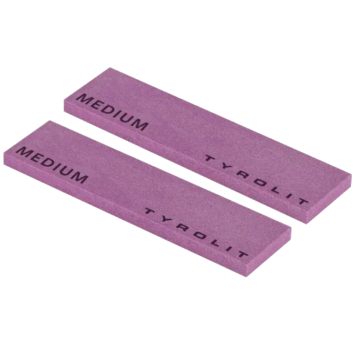 Two purple whetstones with the inscription "MEDIUM" and "Tyrolit" lie diagonally on top of each other.