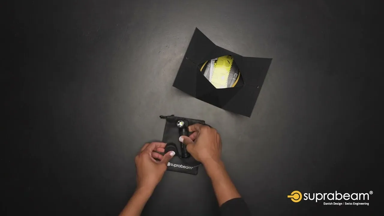 Die Suprabeam M6xr BodyGuard Lampe wird in ihrer Verpackung präsentiert. Hand packt die Lampe in einen Beutel.