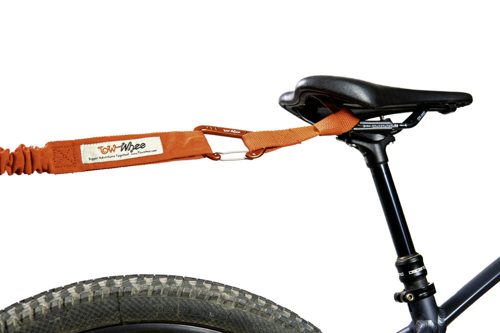 Nahaufnahme eines Fahrradsattels mit einem Tow-Whee Quick Loop, der mit einem Karabiner befestigt ist.