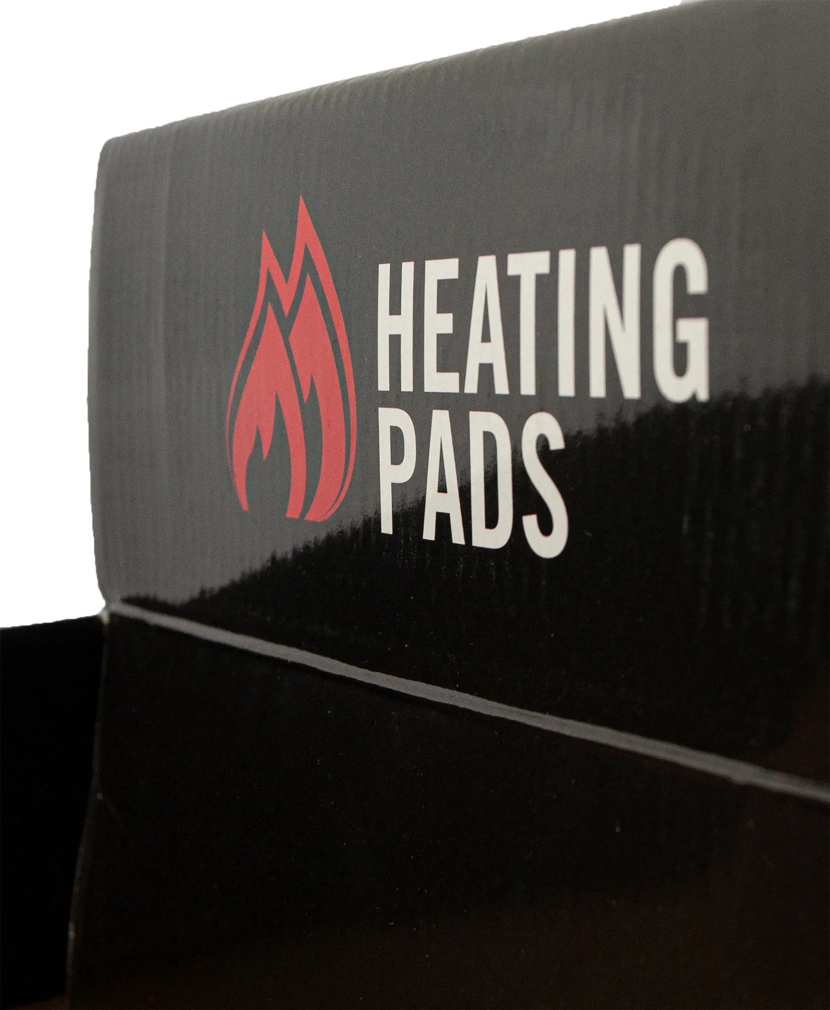 Emballage en carton noir, inscription "HEATING PADS" en blanc, symbole de flamme rouge à côté.