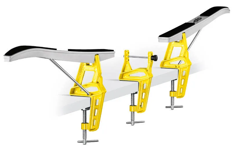 Yellow Toko Ski Vise Nordic World Cup for fixing skis, mounted on a table edge with clamped skis.