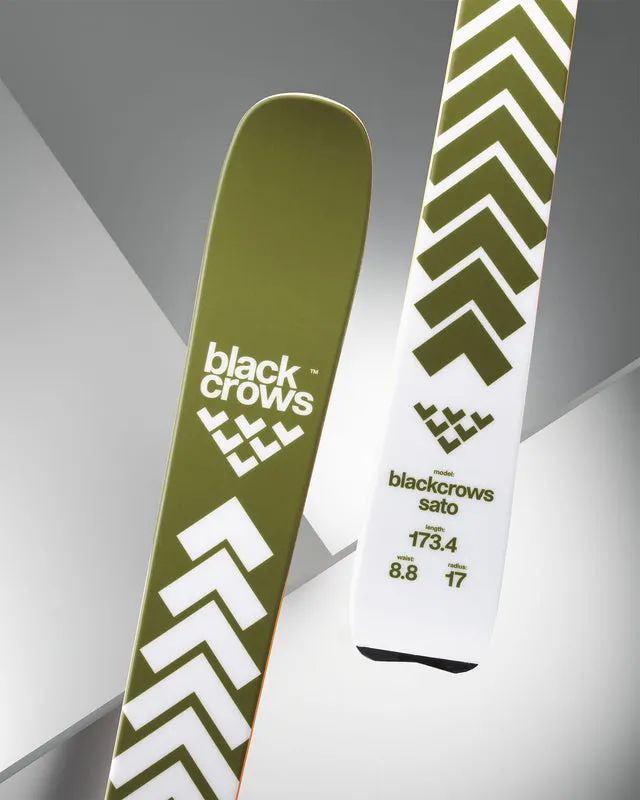 Due sci del marchio Black Crows, uno verde oliva e l'altro bianco, entrambi con motivo chevron e dati tecnici.