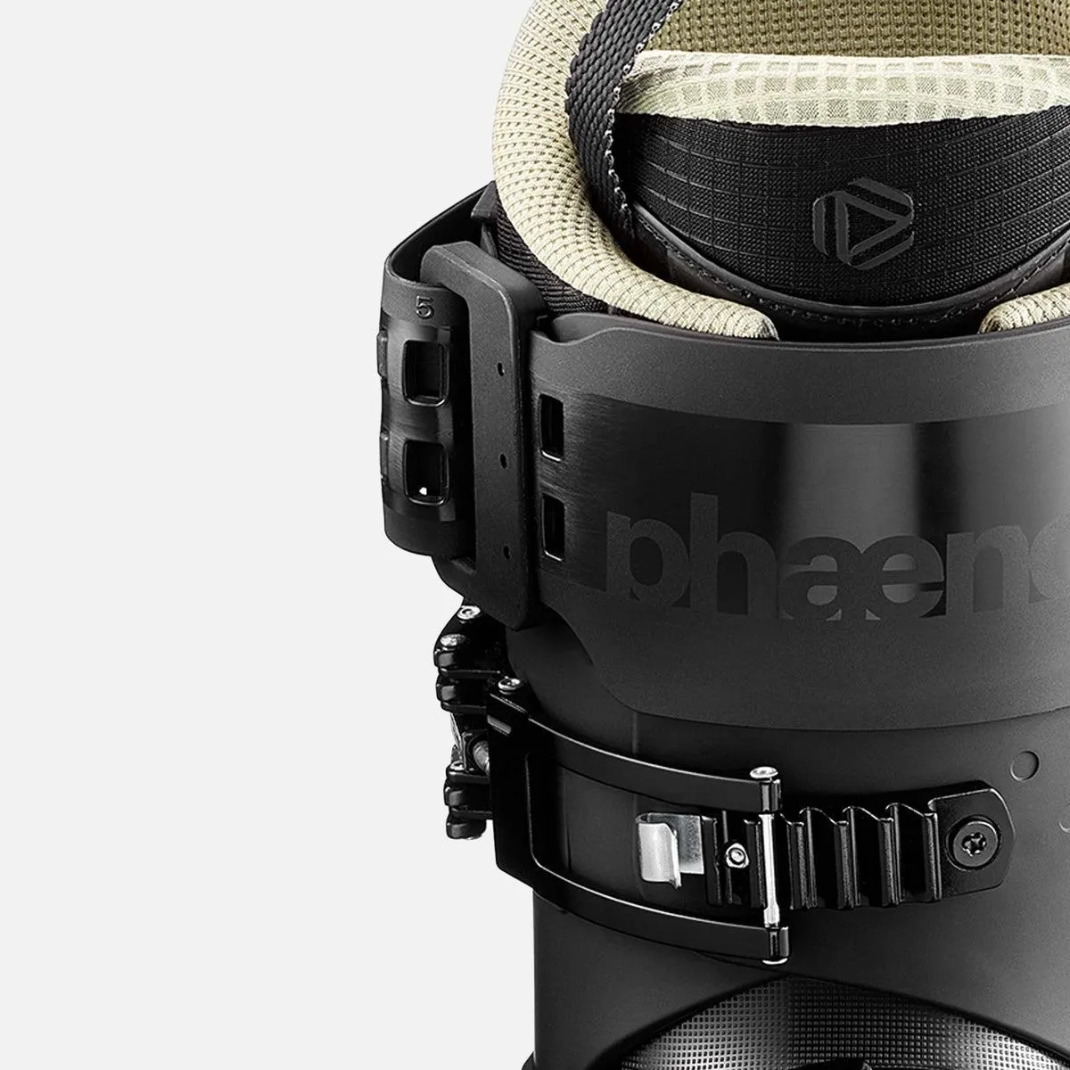 Close-up of a black snowboard binding with strap and buckle against a light background.