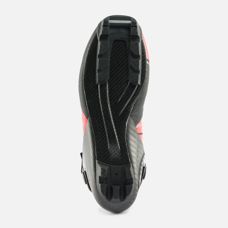 Nahaufnahme der Unterseite eines Rossignol X-IUM Carbon Premium Skate Skischuhs mit Carbonsohle, roten Details und schwarzer Bindung.