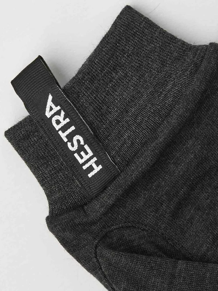 Close-up of a gray Merino Wool Liner Active glove with the Hestra logo on the cuff.