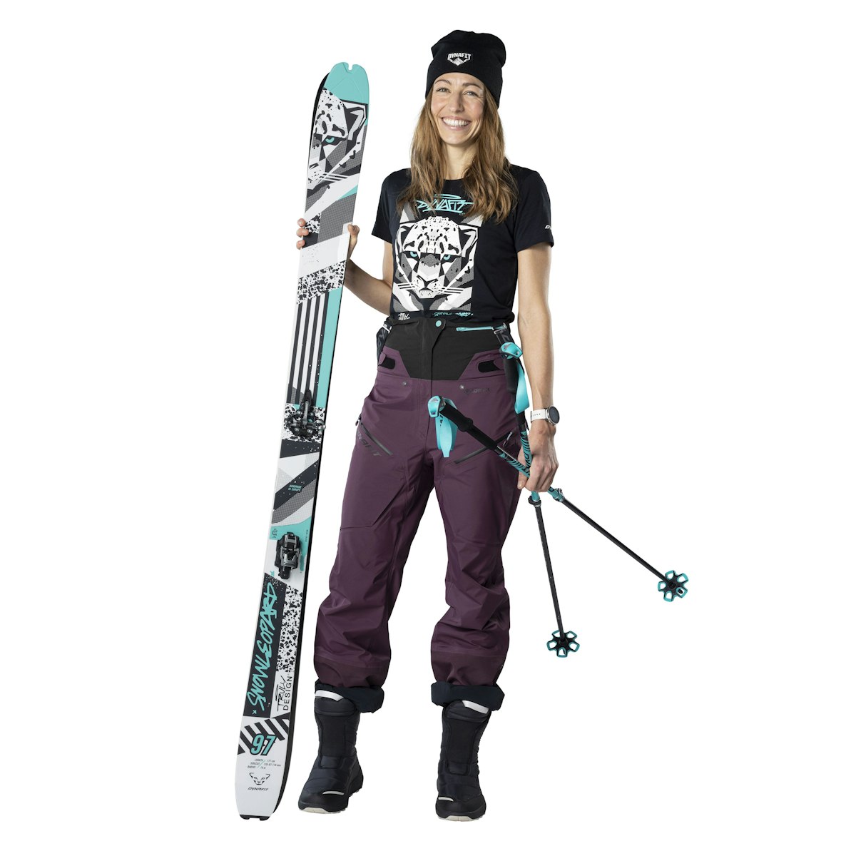 Skifahrerin mit Ausrüstung Frau mit Ski-Ausrüstung: Ski, Hose, Stöcke. Ski mit Aufdruck.